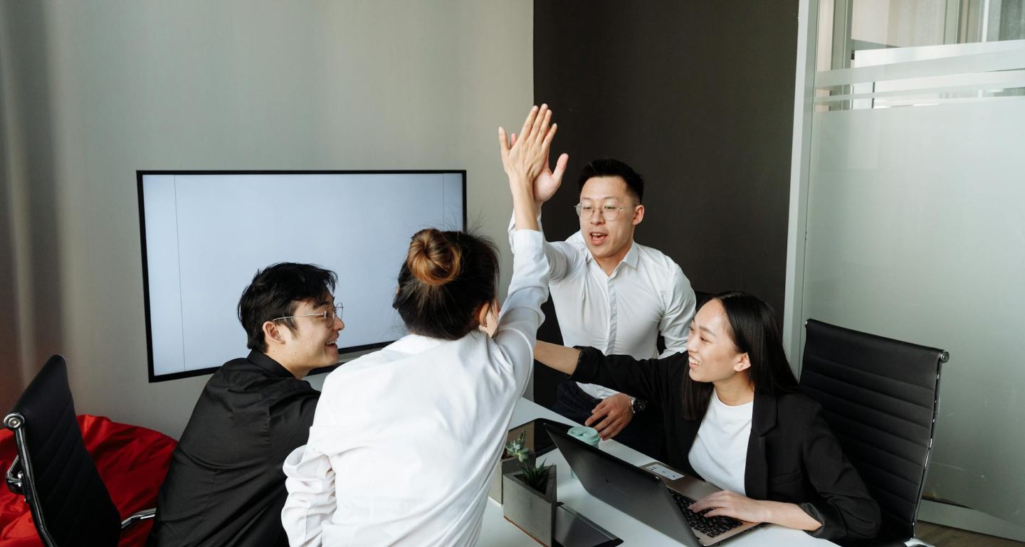Group of colleagues high-fiving in a modern office