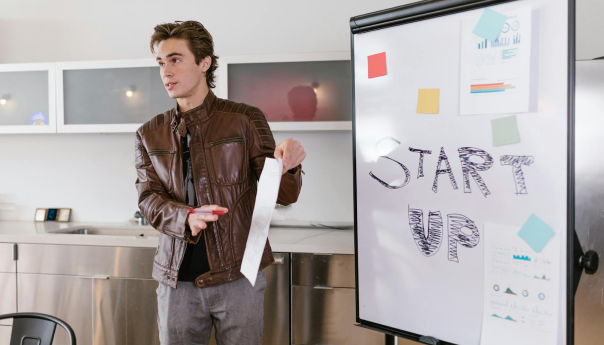 Young man giving a startup presentation with a whiteboard